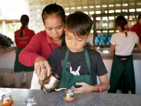 Boy pouring new layer into candle