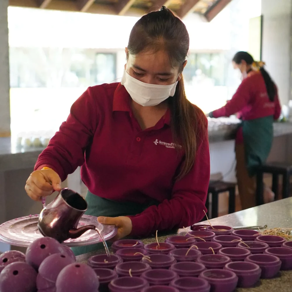 Artisan fills the candle mould which will create half of that ball candle