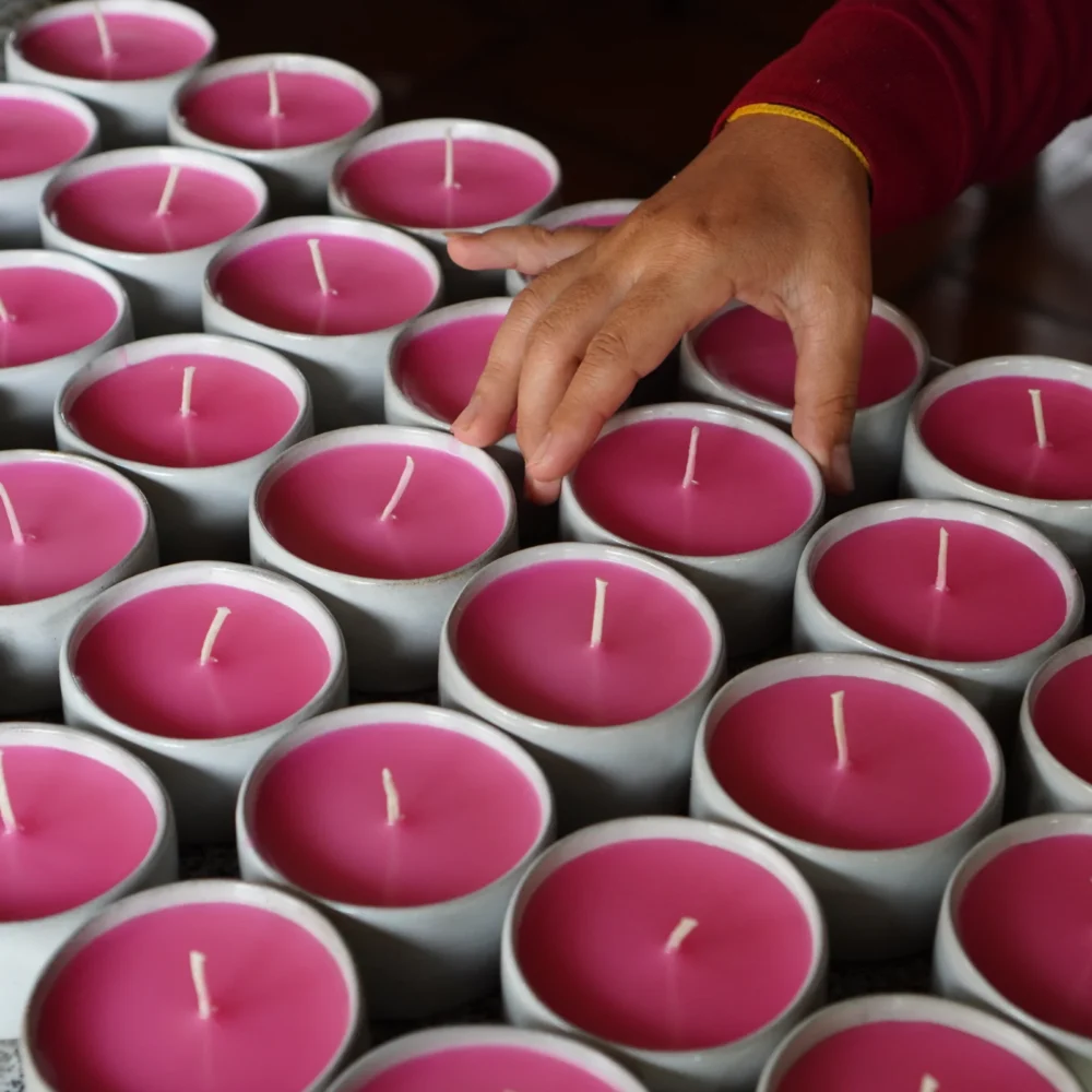 Candle in ceramic, making process, artisan's hand about to pick one candle