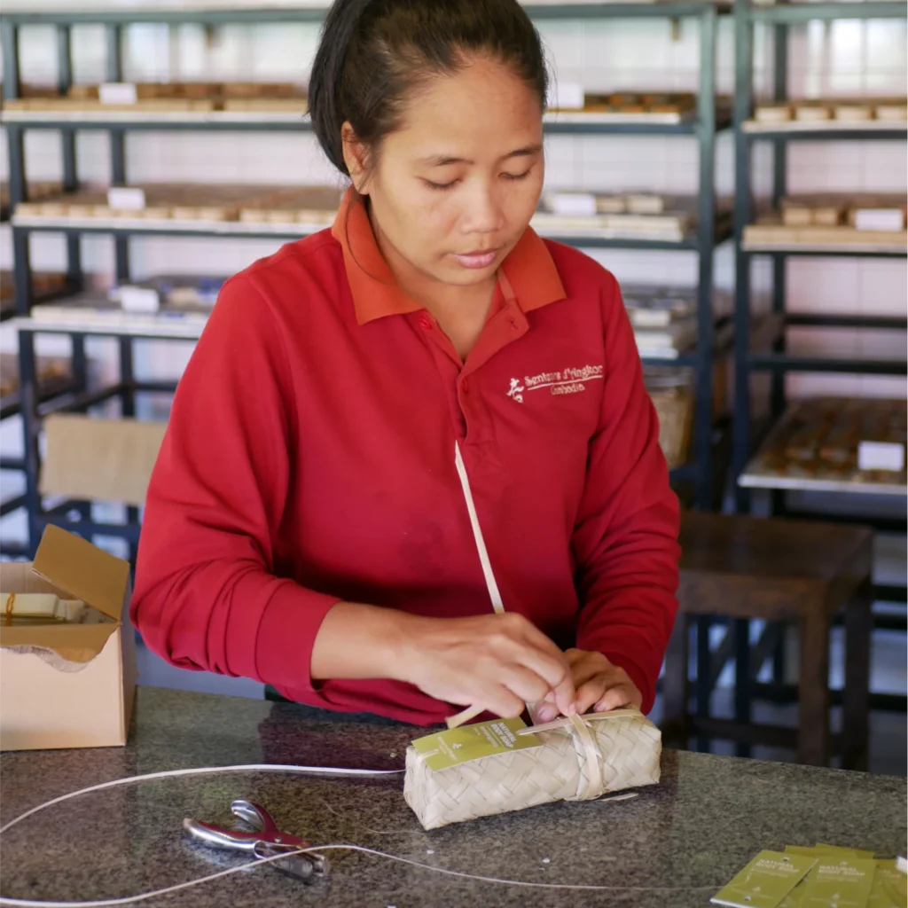 Artisan packing lemongrass Natural Body Soap inside its Smok packaging.