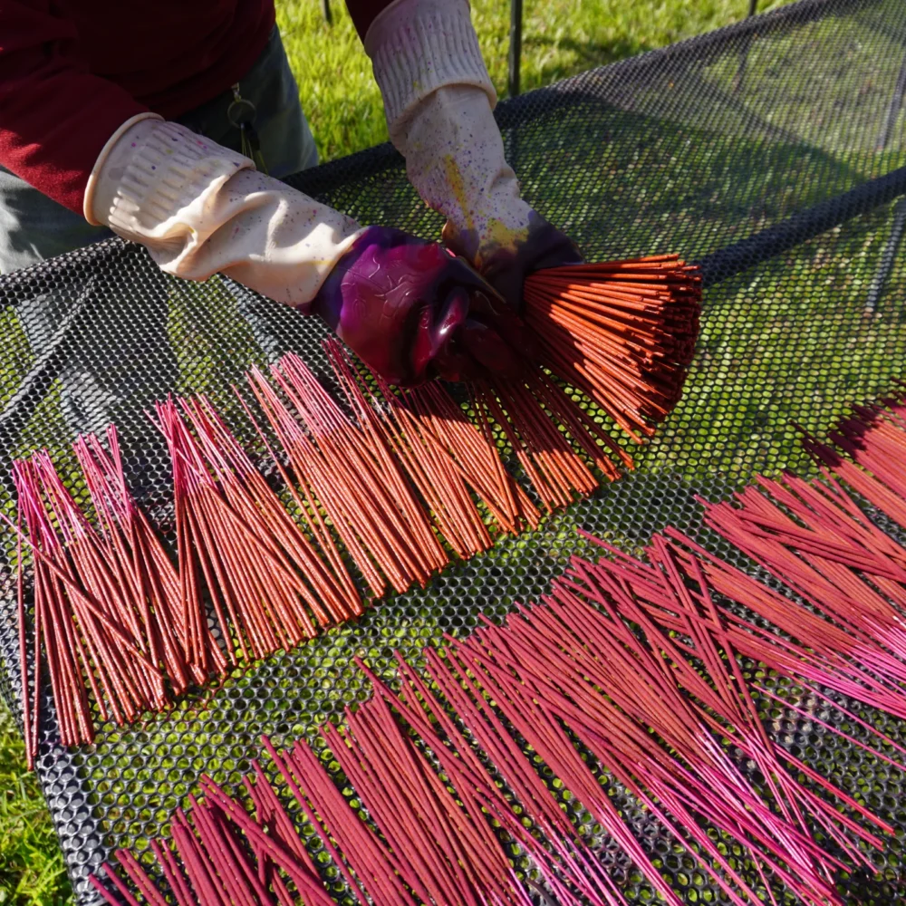 Artisan laying incense sticks on tray