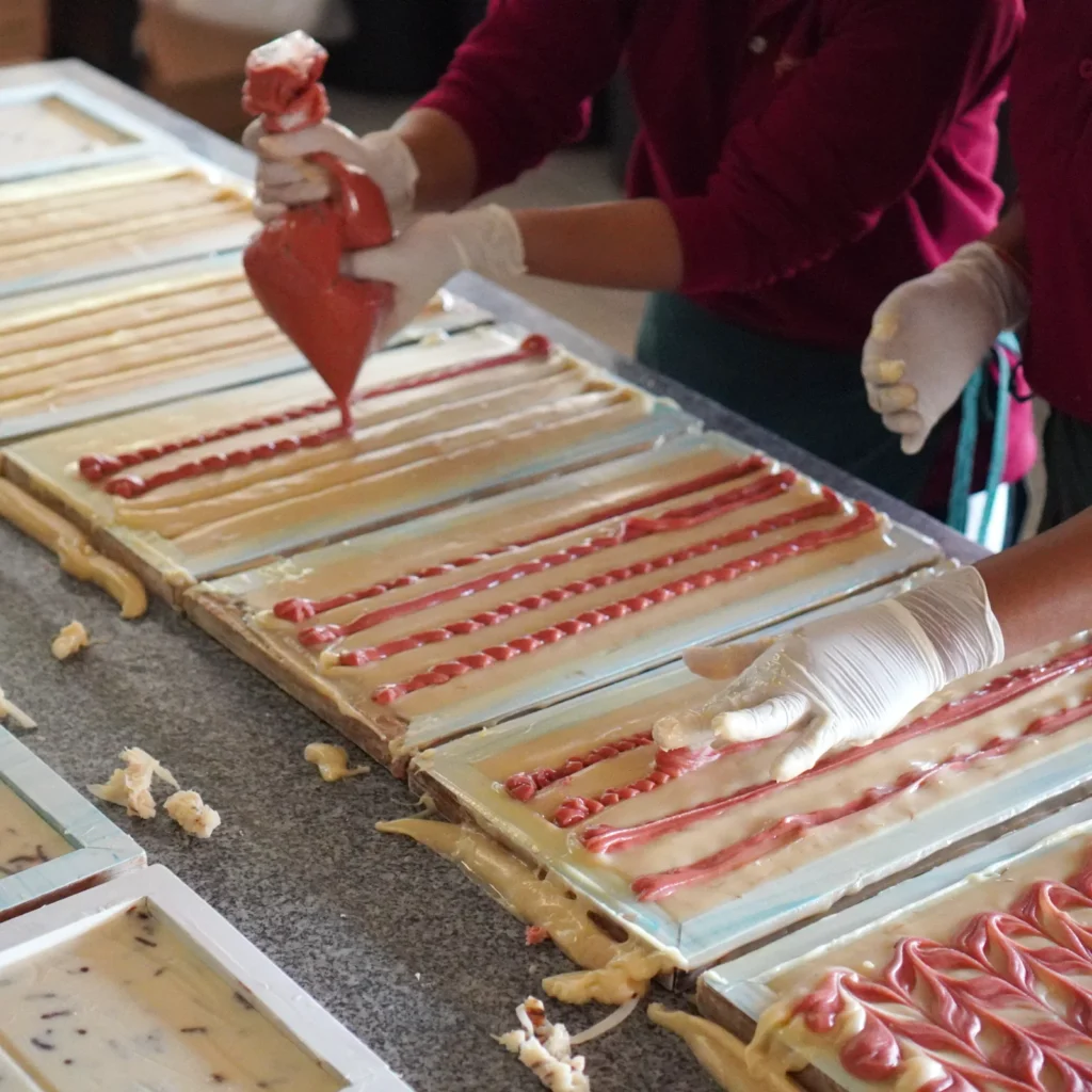 Artisans applying second colour on marble soap