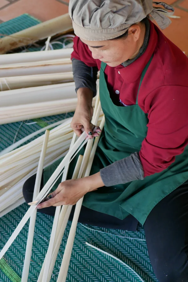 Woman artisan processing banana palm fibre that will be used for packaging.