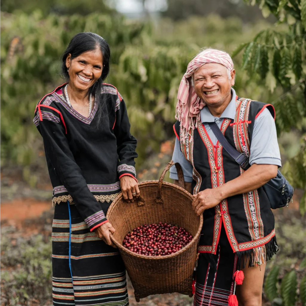 2 farmers lifting their traditional backpack and show us the coffee beans they collected.
