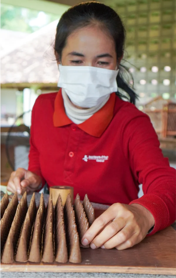 Artisan aligning incense cones for drying