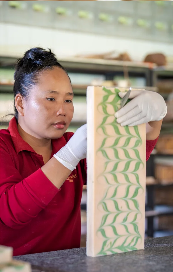 Artisan cutting soap bar to make individual soap